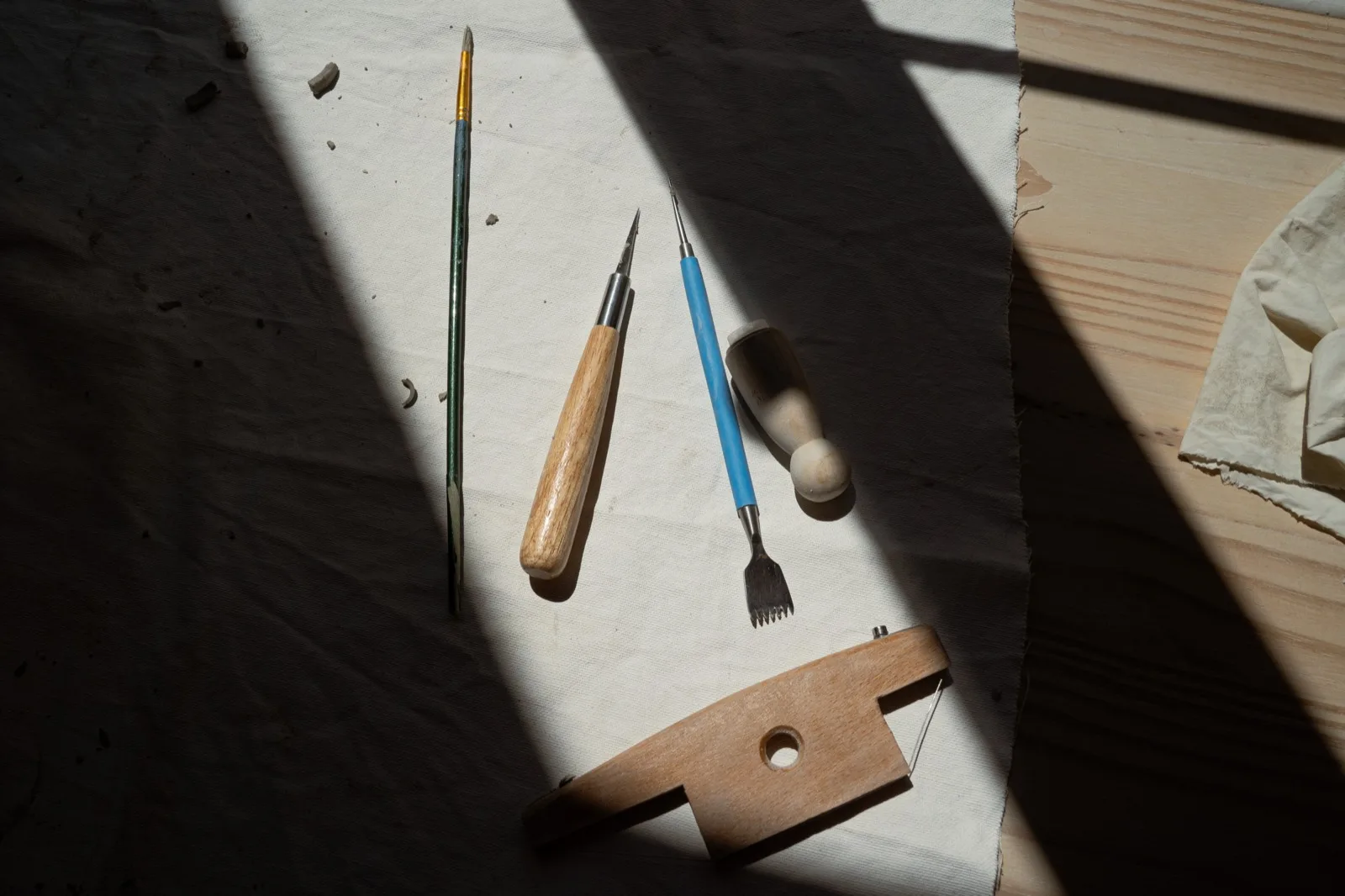 Mirettes, pinceaux et estèques posés sur la table de l'atelier