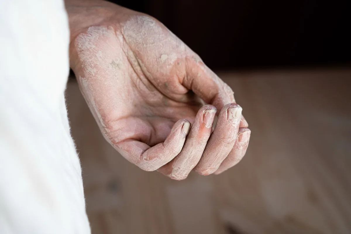 Main couverte de terre sèche, à la sortie de l'atelier